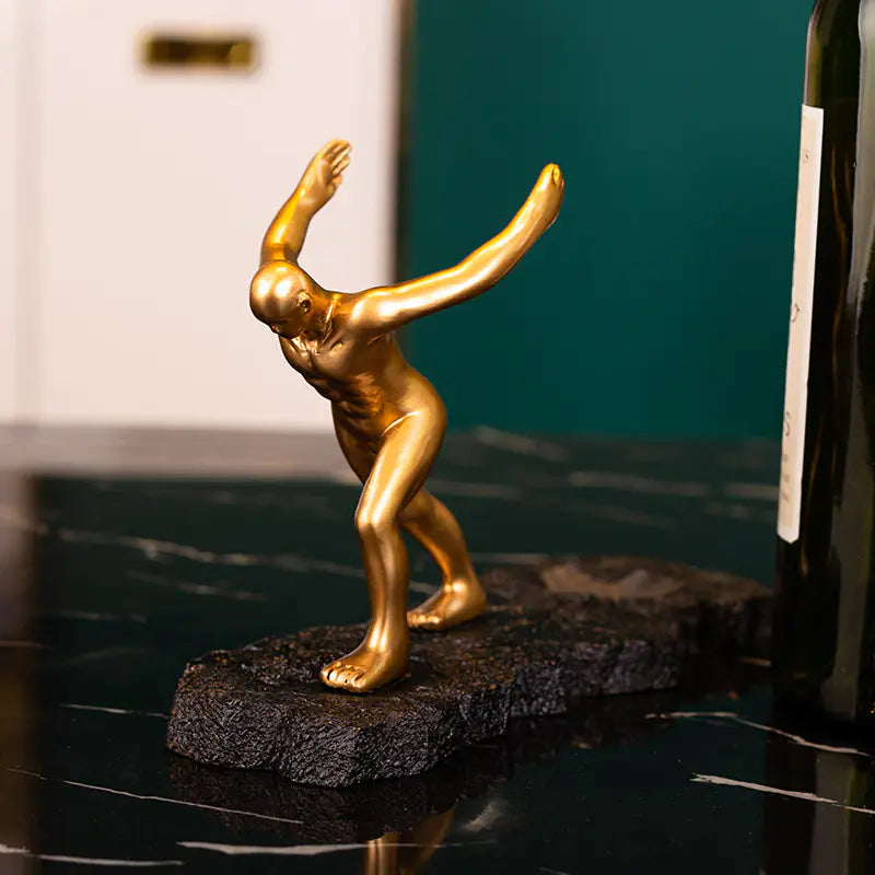 Artistic gold figurine on a dark surface as a decorative wine rack for cabinet