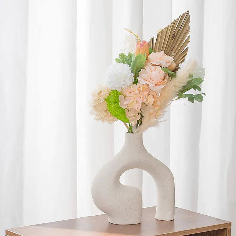 Nordic ceramic vase decor with colorful artificial flowers on a wooden table