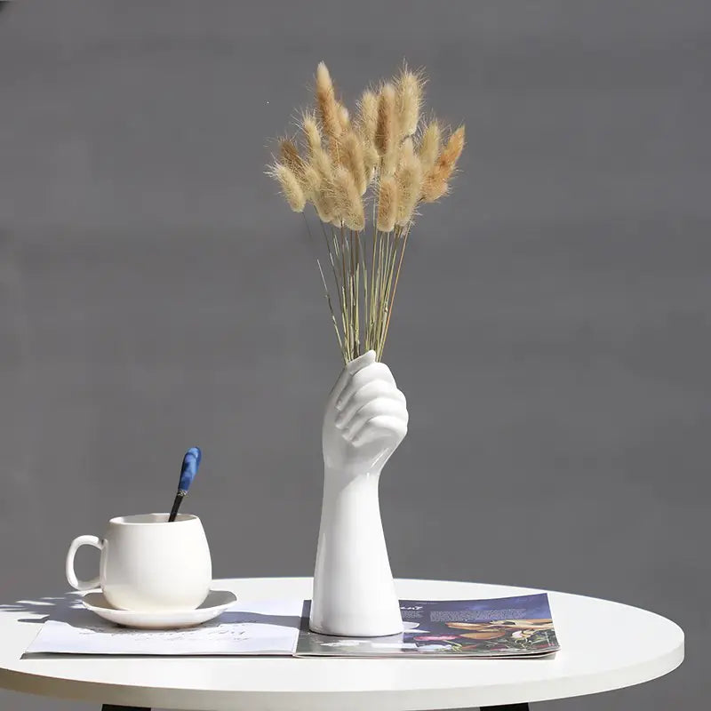 Nordic vase with dried flowers showcased on a table with a coffee cup and magazines